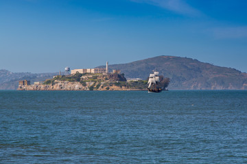 A Tall Sailing Ship on the Horizon Near Alcatraz Island on a Hazy Day