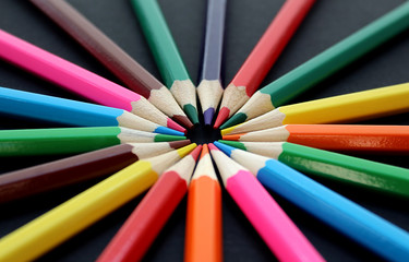 Fototapeta premium colorful bright pencils lie all around on a black background