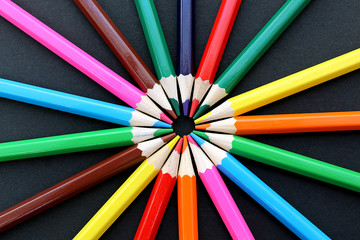 Fototapeta premium colorful bright pencils lie all around on a black background