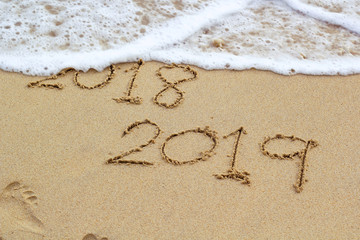 New Year 2019 sign in tropical beach sand with turquoise ocean