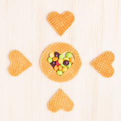 Traditional belgian waffles form of heart with fresh blueberry and sweet cherry on white wooden background. Flat lay, top view, copy space.