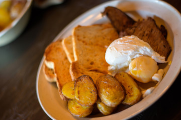 Steak and eggs brunch Closeup of rustic brunch breakfast plate homemade eggs and steak with potatoes and toast