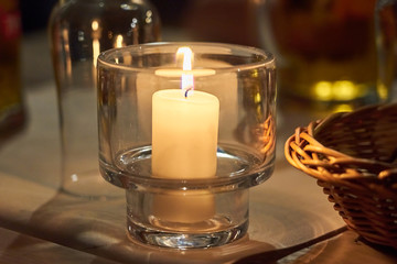 Candle on a table with blurred background bokeh.