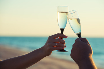 A loving couple drinks champagne on the seashore. Romantic.