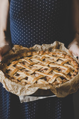 Hands holding homemade delicious apple pie. Close up