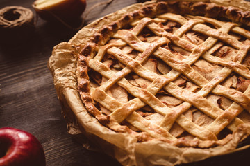 Traditional homemade delicious apple pie on the wooden table. Close up
