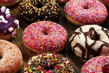 assorted donuts with chocolate frosted, pink glazed and sprinkles donuts