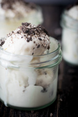 Ice cream with chocolate cookies in glass jars.