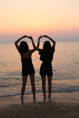 girls doing infinite sign on seaside