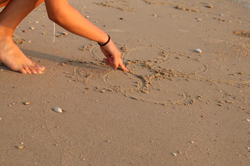Fototapeta na wymiar finger writing on sand on beach