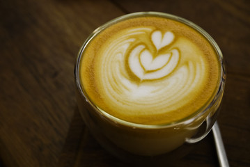 Tulip pattern latte art over freshly brew espresso coffee in a glass. Good for caffeine boost in the morning. Selective focus. Close up.