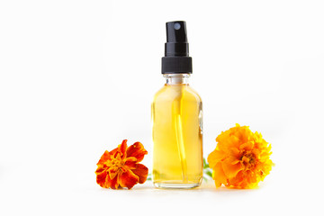 marigold essential oil in  beautiful bottle on White background