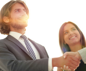 Businesspeople  shaking hands against room with large window loo