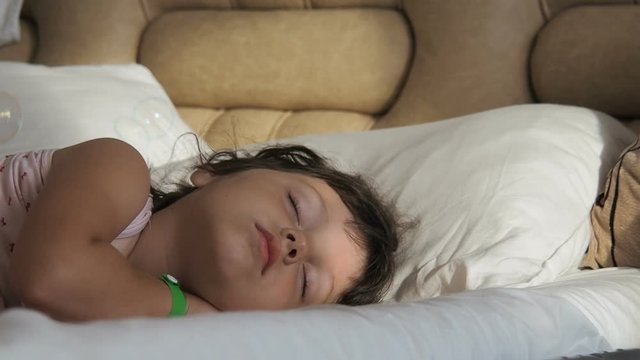 A beautiful sleeping child. A little girl is sleeping in soap bubbles.