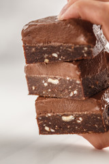 Stack of chocolate fudge bars on white background. Raw vegan dessrt.