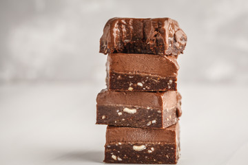 Stack of chocolate fudge bars on white background. Raw vegan dessrt.