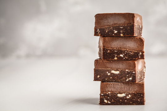 Stack Of Chocolate Fudge Bars On White Background. Raw Vegan Dessrt.