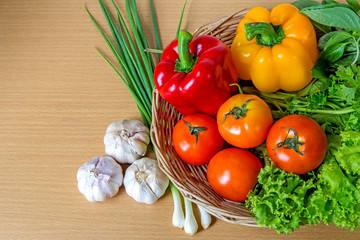 Organic vegetables in the wicker basket on wooden background
