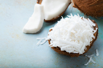 Coconut flakes in a shell on a blue background. with copy space