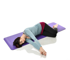 Mother woman exercising doing postnatal workout. Female fitness stretching hands and legs in gym...