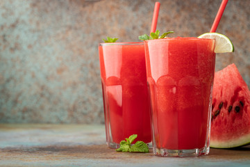 Watermelon slushie with lime, summer refreshing drink in tall glasses on a blue rusty background. with copy space
