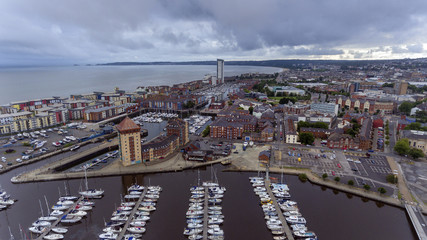 Fototapeta premium Editorial SWANSEA, UK - AUGUST 12, 2018: An aerial view of the new coastal housing and the Meridian Tower at the marina area of Swansea Bay, South Wales, UK