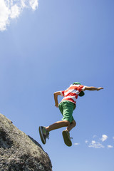 Obraz premium boy jumping off a rock