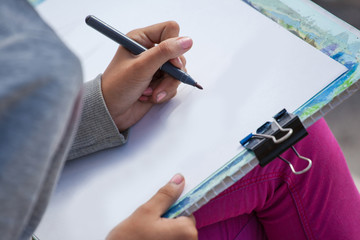 girl painter draws outdoors, close up