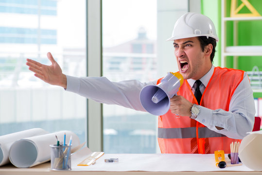 Construction supervisor with loudspeaker sitting in the office 
