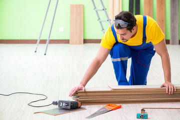 Professional contractor laying flooring at home