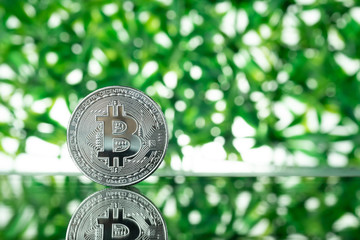 Bitcoin digital currency,  bit-coin on green blurred bokeh background, Cryptocurrency money concept.