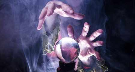 A fortune teller tries to look into the future with a crystal ball
