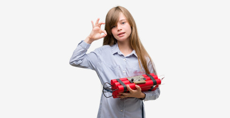 Young blonde child holding dynamite bomb doing ok sign with fingers, excellent symbol