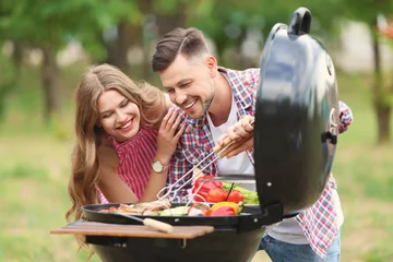 Tuinposter Young people having barbecue with modern grill outdoors © New Africa