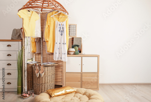 Stylish Dressing Room Interior With Wooden Furniture And Clothes