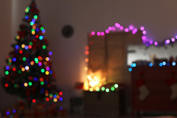 Blurred view of stylish living room interior with Christmas lights at night
