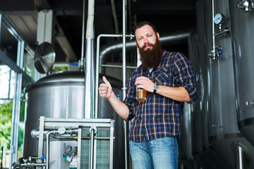 brewer giving thumbs up with craft beer made in brewery