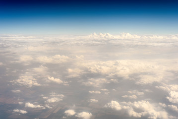 Naklejka na ściany i meble Huge cloudscape of clouds taken from an aerial position from the window of a plane high above the cloudline
