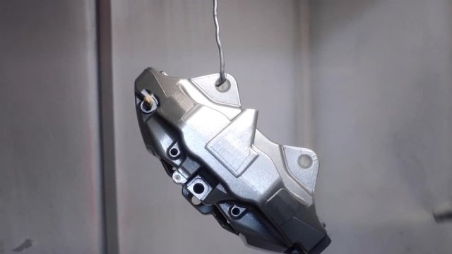 The painter paints the details of the car's brake system