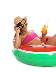 Beautiful young woman with inflatable ring and glass of cocktail on white background