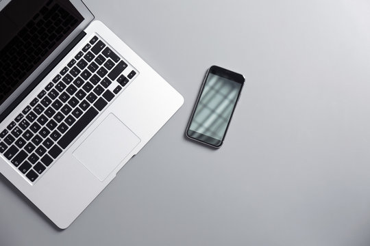 Modern Laptop And Mobile Phone On Gray Background, Top View