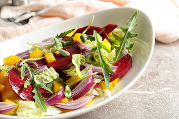 Bowl with tasty beets salad on gray table