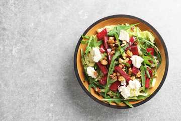 Bowl of tasty beets salad on gray table, top view with space for text