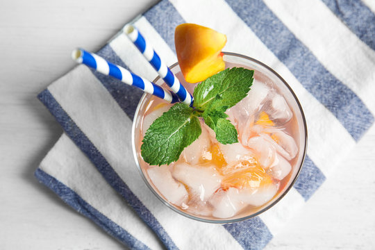 Tasty peach cocktail in glass on table, top view. Refreshing drink