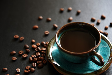black coffee and coffee bean On the black table Top view