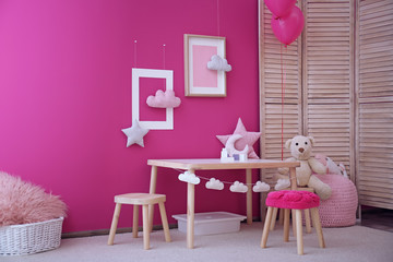 Modern interior of child game room with table, chairs and toys