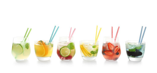 Glasses with tasty lemonades on white background