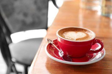 Cup of fresh aromatic coffee on table