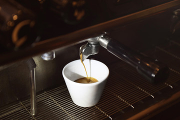 Preparing fresh aromatic coffee on modern machine, closeup