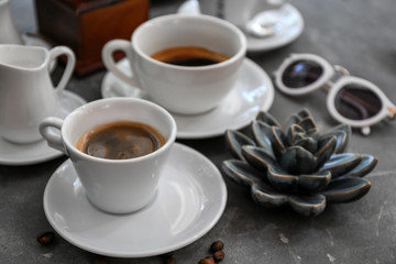 Cups of fresh aromatic coffee on grey background